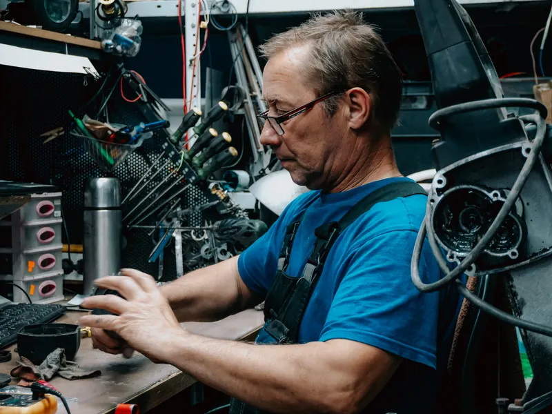 Technician working with hand tools in a well-equipped workshop